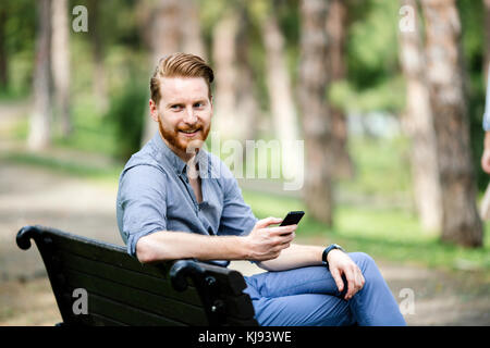 Gut aussehender Geschäftsmann mit Mobiltelefon Stockfoto