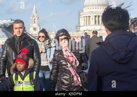 London, Großbritannien. 23 Nov, 2017. Menschen kämpfen mit den blustery kaltem Wetter zu Fuß auf Millenium Bridge London mit den Winden, die wahrscheinlich bei bis zu 60 mph in einigen Orten Gutschrift zu Gust: Amer ghazzal/alamy leben Nachrichten Stockfoto