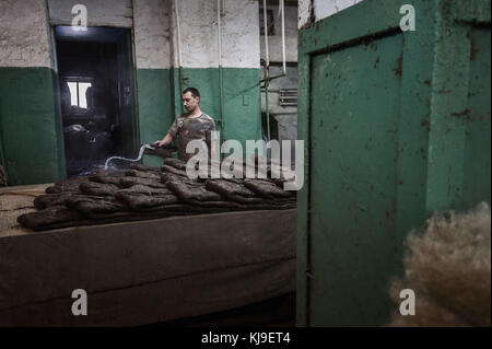 Dezember 6, 2016 - syktyvkar, Komi Republik, Russland - die Arbeiter Gewässer der Wolle Schuhe in Produktion.. die Produktion der traditionellen russischen Schuhe aus Wolle auf Wolle vylgort Footwear Fabrik hergestellt. Die vylgort wolle Schuhe Fabrik produziert Schuhe seit über 75 Jahren. (Bild: © Sergey parshukov/Sopa über Zuma Draht) Stockfoto