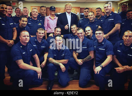 Riviera Beach, Florida, USA. November 2017. US-Präsident Donald Trump und First Lady Melania Trump posieren für ein Gruppenfoto mit Coast Guardsmen am Thanksgiving Day während eines Besuchs der US-Küstenwache Lake Worth Inlet am 23. November 2017 in Riviera Beach, Florida. Quelle: Planetpix/Alamy Live News Stockfoto