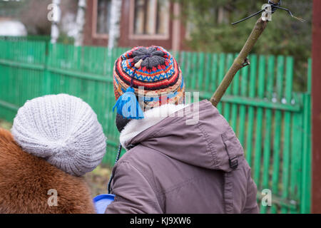 Zwei fremde Frauen gehen mit einem Holzstab, Outdoor 7/8 Shot Stockfoto