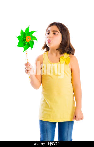 Schöne Mädchen bläst eine Kunststoff Windmühle Stockfoto