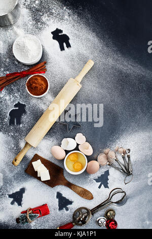 Alte hölzerne Rolling Pin mit Gebäck Zutaten und Küchengeräte über eine Mehl liegend entstaubt Hintergrund. Bild geschossen von oben. Stockfoto