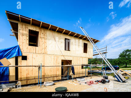 Gebäude energieeffizient passive Holzhaus. Baustelle und außen eine hölzerne Verkleidung Haus mit Gerüsten für Wand Isolierung bereit. Stockfoto