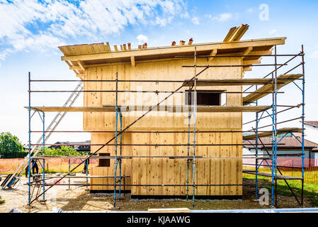 Gebäude energieeffizient passive Holzhaus. Baustelle und außen eine hölzerne Verkleidung Haus mit Gerüsten für Wand Isolierung bereit. Stockfoto