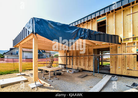 Gebäude energieeffizient passive Holzhaus. Baustelle und außen eine hölzerne Verkleidung Haus mit Gerüsten für Wand Isolierung bereit. Stockfoto