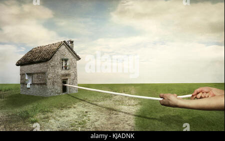 Eine schöne Landschaft mit zwei menschlichen Händen, ein Haus mit einem Seil ziehen Stockfoto