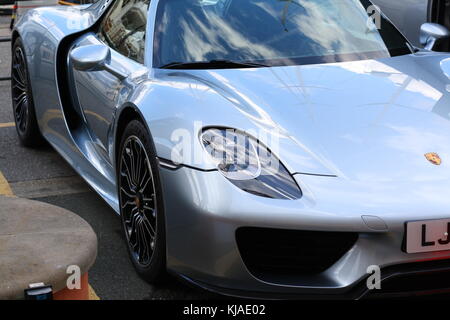 Ein Porsche 918 Spyder in Genua geparkt, vor einer Yacht. Stockfoto