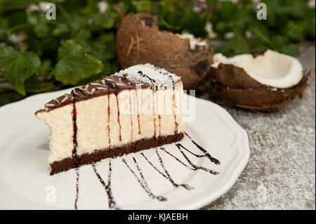 Kokosnuss Kuchen mit Schokolade auf einem weißen Teller Stockfoto