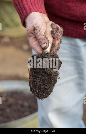 Gärtner hand Halten einer Hand Kelle. Großbritannien Stockfoto