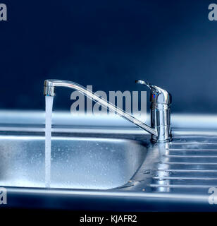 Reines Wasser fließt vom Kran auf Küche Stockfoto