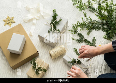 Weihnachtsgeschenke eingepackt und mit Zweigen dekoriert Stockfoto