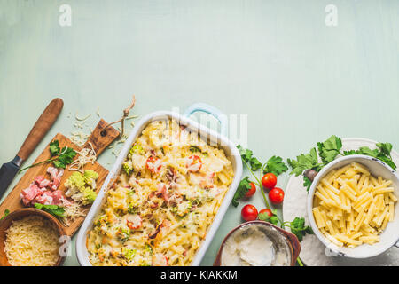 Pasta Kasserolle mit Romanesco Kohl und Schinken in cremiger Sauce, am Küchentisch Hintergrund mit Zutaten, Ansicht von oben, Grenze. italienische Küche Stockfoto