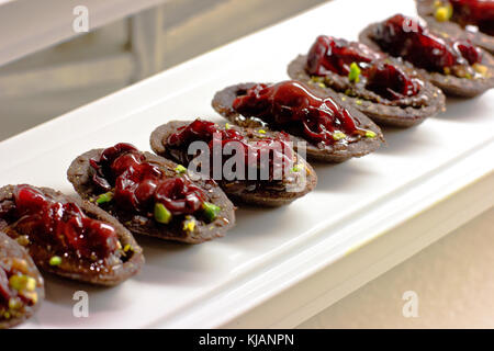 Schoko Törtchen mit den Beeren, Kirschen und Muttern Stockfoto