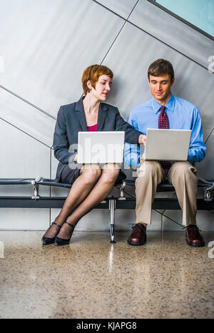 Ein Geschäftsmann und Geschäftsfrau die Arbeit an Ihrem Laptop Computer. Stockfoto