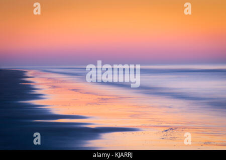 Wellen in Bewegung wie Sie Abstürzen am Strand bei Sonnenaufgang Stockfoto