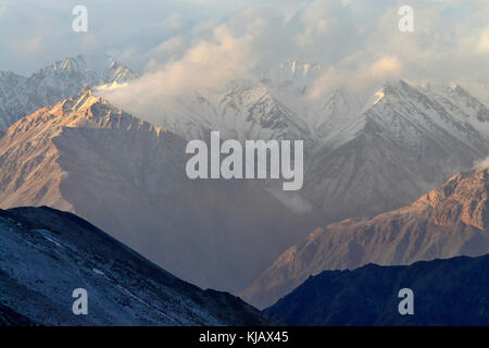 Hohe Berge: Ketten von Graten nach oben steigen, Spitzen werden mit ewigen Gletschern bedeckt, von den Bergen Nebel ins Tal abfällt. Stockfoto