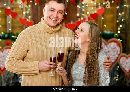 Junge und Mädchen trinken Wein, der am Valentinstag Stockfoto