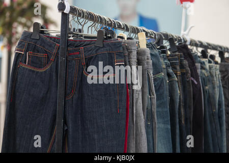 Reihe von Jeans und Hosen auf Kleiderbügel für Verkauf. Stockfoto