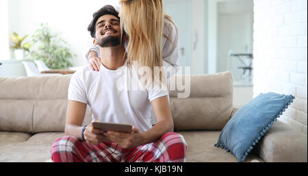 Nettes Paar entspannen auf der Couch mit Tablette zu Hause Stockfoto