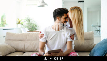Nettes Paar entspannen auf der Couch mit Tablette zu Hause Stockfoto