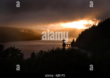 Dramatische Abend Licht über Lake Vyrnwy, Wales, UK als Sonne durch Gewitterwolken