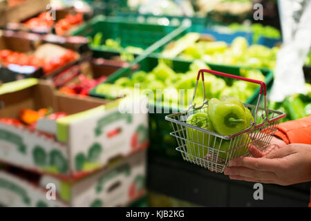 Gemüse im Supermarkt. Kauf grüner Paprika im Shop. kleinen Korb. Stockfoto