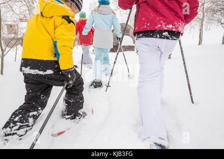 Ansicht der Rückseite des Kaukasischen Familie Schneeschuhwandern Stockfoto