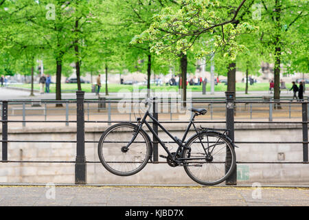 Schwarzes Fahrrad, Ansicht eines schwarzen Fahrrads, das an Geländer in der Nähe des Lustgartens in Berlin, Deutschland, Europa, angekettet ist Stockfoto