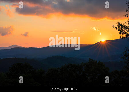 Die Sonne geht hinter einem Bergrücken in der Nähe von Blowing Rock in den Blue Ridge Mountains von North Carolina. Stockfoto