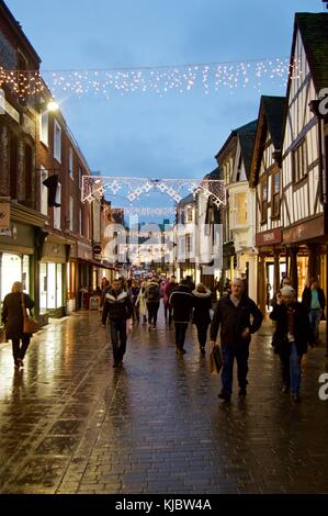 Shopper unter Weihnachtsbeleuchtung in der High Street, Winchester, Großbritannien Stockfoto