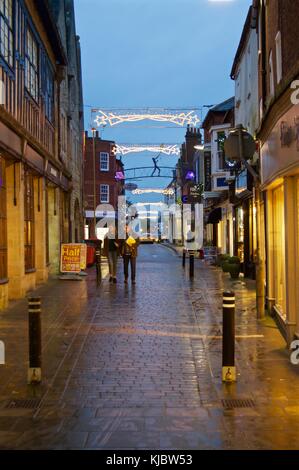 Shopper unter Weihnachtsbeleuchtung in der High Street, Winchester, Großbritannien Stockfoto