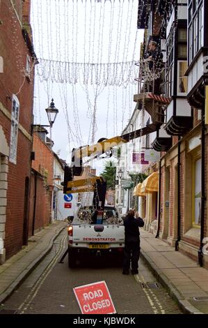 Zwei Männer, Weihnachtsbeleuchtung auf Winchester High Street von Cherry Picker, Winchester, Großbritannien Stockfoto