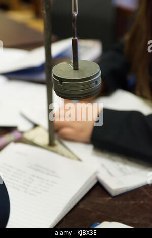 Schule Wissenschaft Kategorie mit der Aufnahme der Schüler Ergebnisse im Notebook Gewichte Massen für die hooke Gesetz experiment Stockfoto