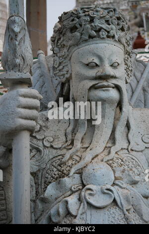 Eine steinerne Statue eines chinesischen Wächter am Eingang des Wat Arun, Bangkok, Thailand. Stockfoto