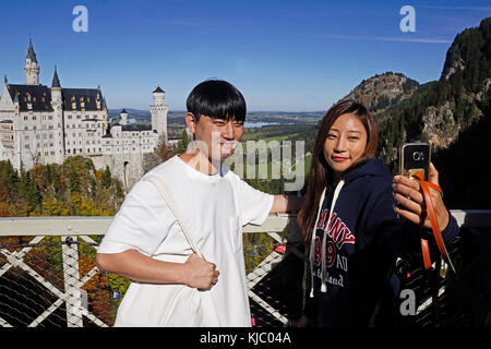 Junge chinesische Touristen ein paar selfie auf Schloss Neuschwanstein in Bayern, Deutschland. Stockfoto