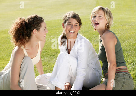 Freunde sitzen auf Gras Stockfoto