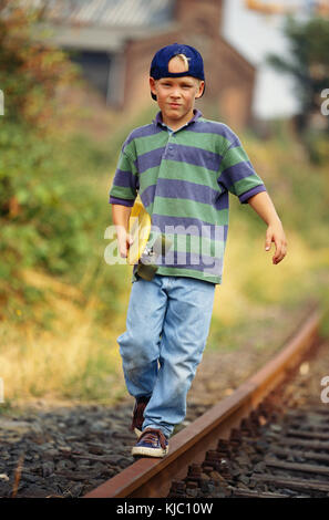 Junge Mit Skateboard Zu Fuß Entlang Der Bahn Tracks Stockfoto