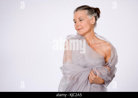 Reife Frau in Schal gewickelt Stockfoto