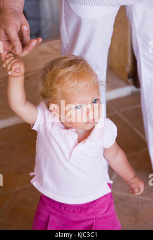 Kleines Mädchen mit dem Finger der Eltern Stockfoto