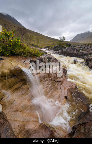 Wasserfall auf dem River Coupal mit bewölktem Himmel bei Glen Coe in Schottland, Großbritannien Stockfoto