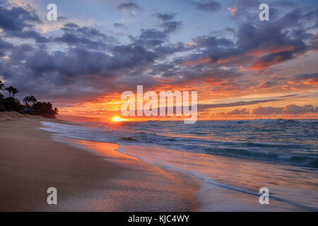 Sonnenuntergang und Surfen am Pazifik am Sunset Beach auf Oahu, Hawaii, USA Stockfoto