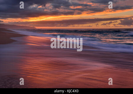 Sonnenuntergang und Surfen am Pazifik am Sunset Beach auf Oahu, Hawaii, USA Stockfoto