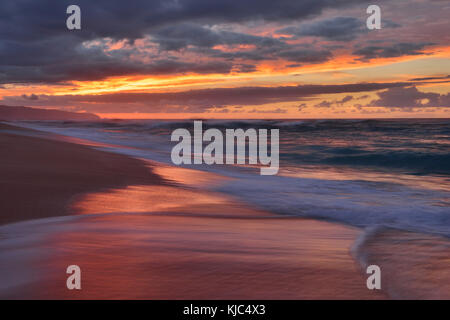 Sonnenuntergang und Surfen am Pazifik am Sunset Beach auf Oahu, Hawaii, USA Stockfoto