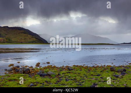 Regenwolken über der grasbewachsenen Küste entlang der schottischen Küste nahe Eilean Donan Castle und Kyle of Lochalsh in Schottland Stockfoto