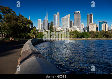 Ufermauer in Farm Cove mit Skyline und Hafen an einem sonnigen Tag in Sydney, Australien Stockfoto