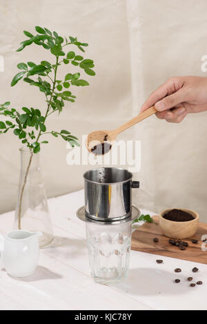 Kaffee tropft im vietnamesischen Stil auf hölzernen Tisch Stockfoto