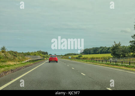 Rotes Auto fahren auf der linken Seite eines ruhigen Autobahn Stockfoto