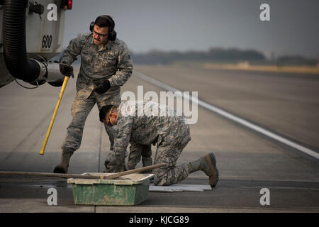 Senior Airman Brendan Kinser, Links, und Senior Airman Imran Farooqi, beide 374 Bauingenieur Squadron Bürgersteige und Ausrüstung gesellen, ein Teil der Start- und Landebahn zu reparieren, November 15, 2017, Yokota Air Base, Japan. Jedes Jahr die 374 CES Reparaturen, im Durchschnitt etwa 125 spall Patches, welche Bereiche von Degradierten Start- und Landebahn mit einer Länge von weniger als 2 m². (U.S. Air Force Foto von älteren Flieger Donald Hudson) Stockfoto