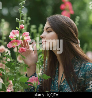 Kaukasische Frau bewundern, rosa Blüten Stockfoto